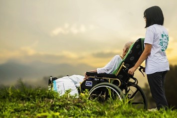 高齢者を車いすで押す女性